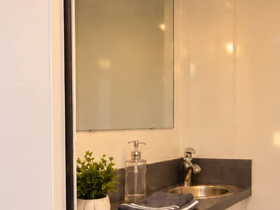 The basin, mirror, soap and folded towels on the counter inside one stall